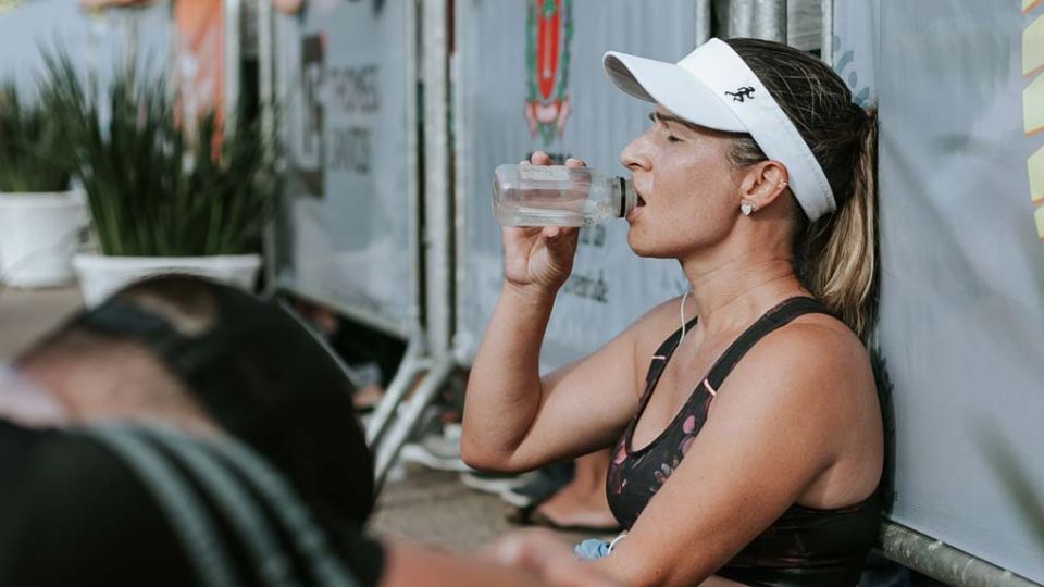 Woman drinking water after finishing a race