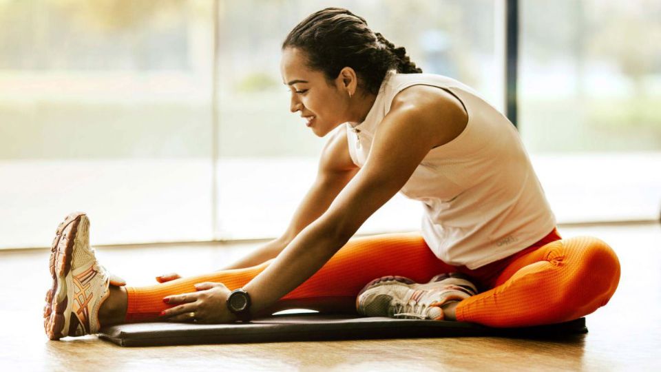 Runner stretching hamstring on floor