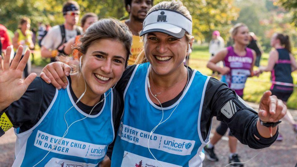 Two female runners laughing and celebrating