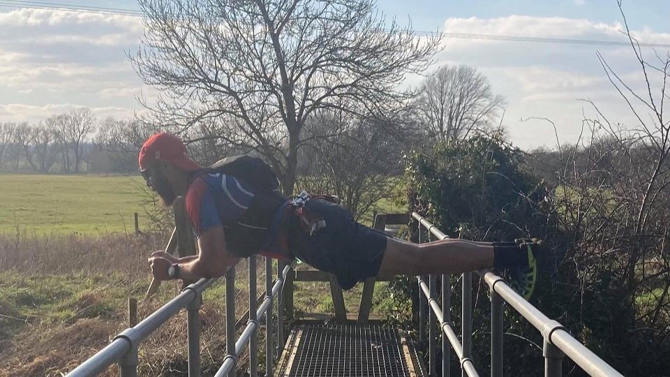 Mike Bullock planks on a bridge