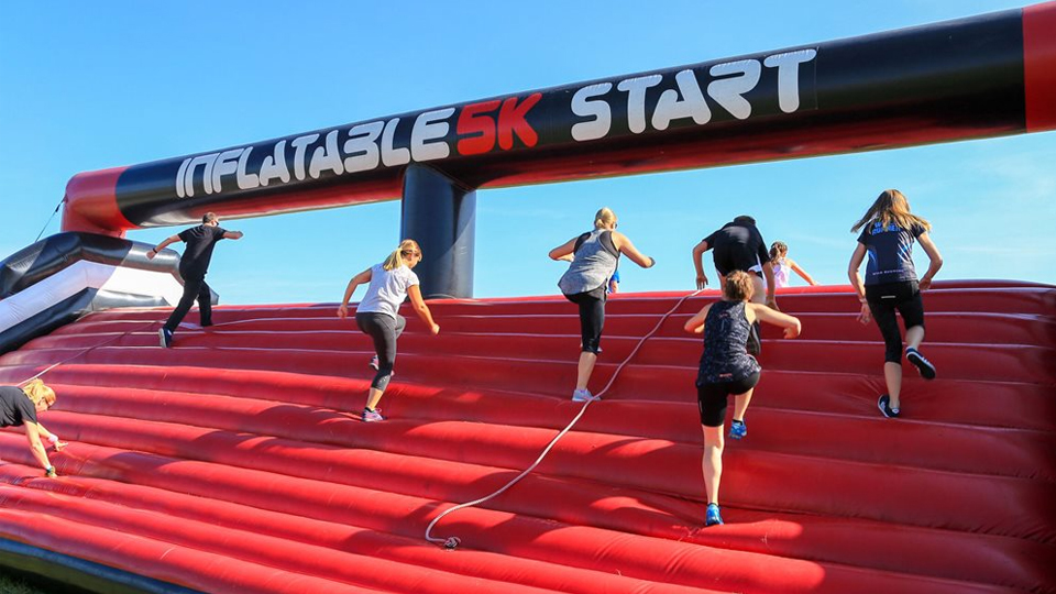 Runners on inflatable assault course