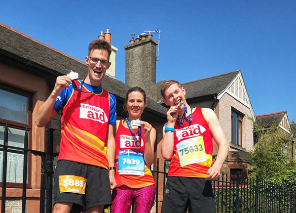 Three happy Christian Aid runners with their EMF medals