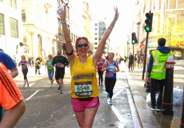 Team Cats runner with arms aloft