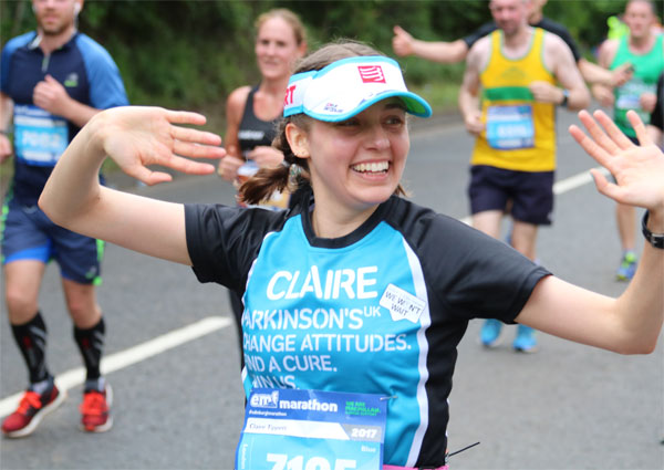 A happy Claire running in her Parkinson's UK vest