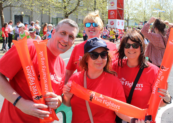 A group of happy runners in bright orange Fire Fighters vests