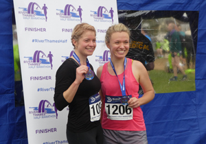 Two happy runners with medals after River Thames Half