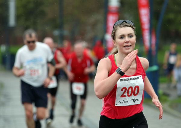 Woman in red vest sprinting at Stockton duathlon