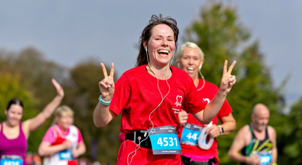 Runner in BHF red vest gives V sign