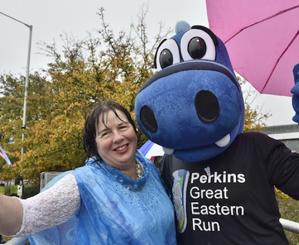 happy runner with dragon mascot post-race