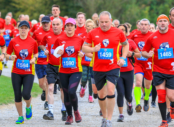 a group of runners in bright red vests