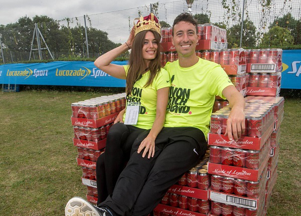 Tom and Jade seated on a pile of cans