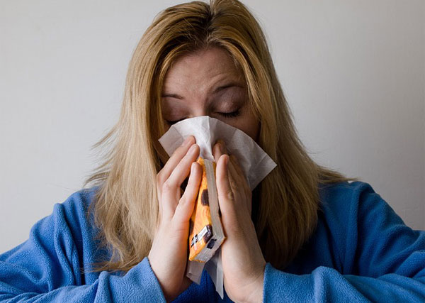 Woman with a runny nose using a hankie